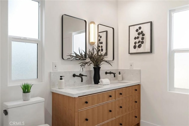 bathroom with backsplash, vanity, and toilet