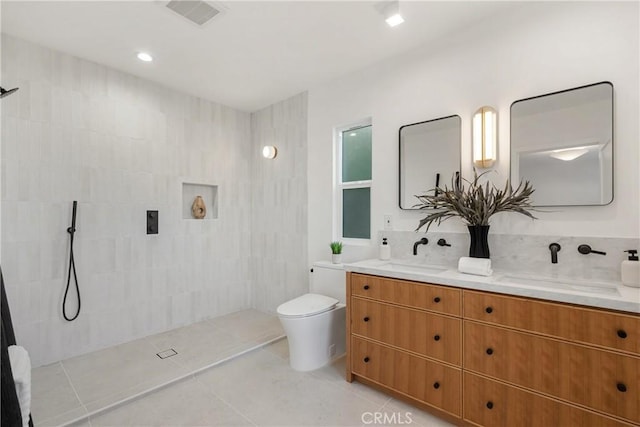 full bath with tiled shower, tile patterned flooring, a sink, and visible vents