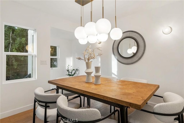 dining space with light wood-style flooring and baseboards