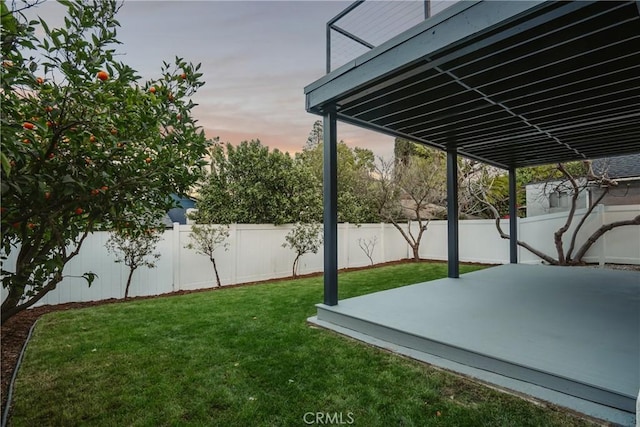 yard at dusk with a patio area and a fenced backyard