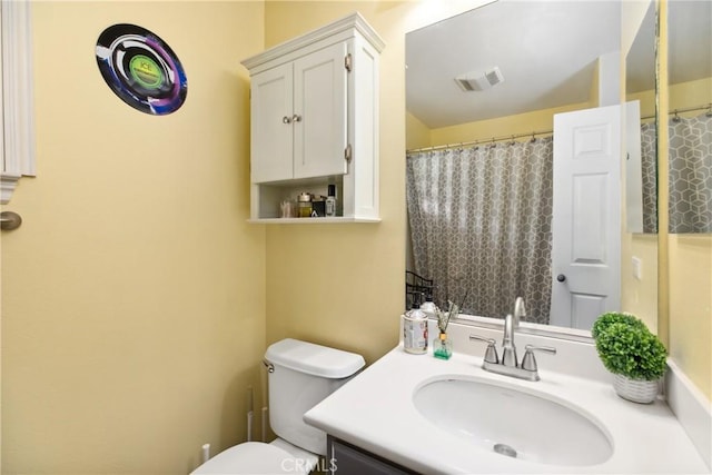 full bathroom featuring curtained shower, visible vents, vanity, and toilet