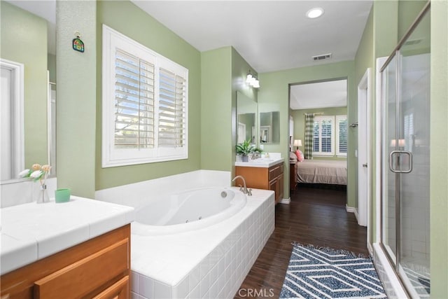 full bath with ensuite bath, a jetted tub, a shower stall, and visible vents