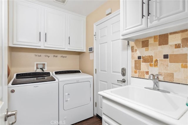 laundry area featuring visible vents, washing machine and dryer, a sink, and cabinet space