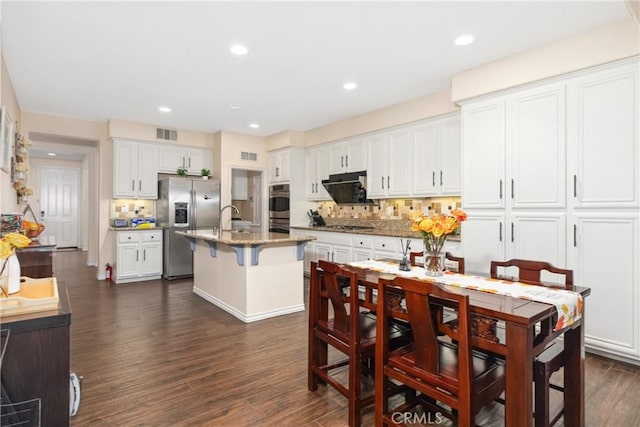 kitchen featuring tasteful backsplash, visible vents, white cabinets, dark wood-style floors, and stainless steel appliances