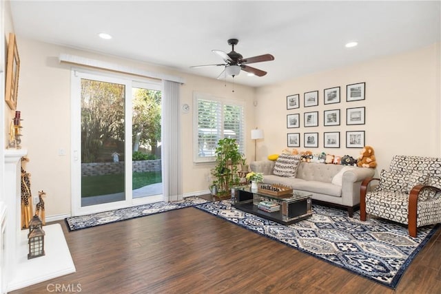 living area featuring baseboards, wood finished floors, a ceiling fan, and recessed lighting