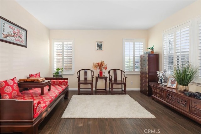 living area featuring dark wood-style flooring and baseboards