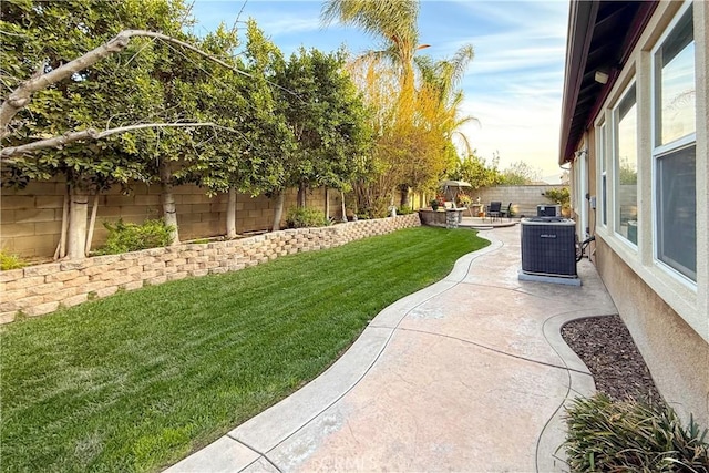 view of yard featuring a fenced backyard, a patio, and central AC unit