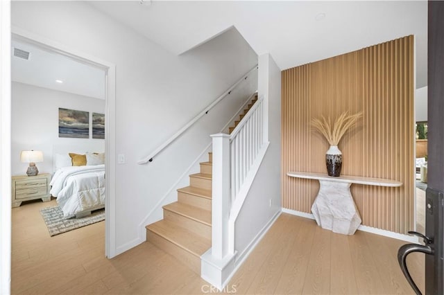 stairway featuring baseboards, visible vents, and wood finished floors