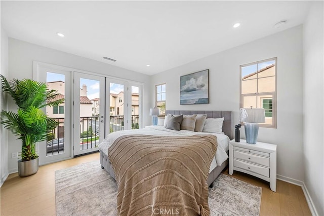 bedroom with access to exterior, french doors, visible vents, wood finished floors, and baseboards