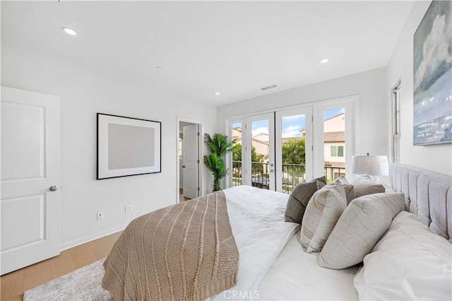 bedroom featuring baseboards, wood finished floors, access to exterior, french doors, and recessed lighting