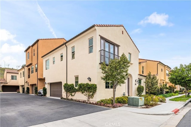 view of building exterior featuring a garage, a residential view, and central AC