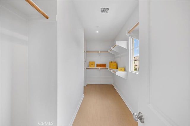 walk in closet with visible vents and wood finished floors