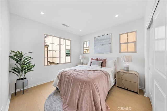 bedroom featuring light wood finished floors, multiple windows, visible vents, and recessed lighting