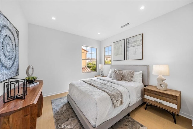 bedroom featuring recessed lighting, visible vents, light wood-style flooring, and baseboards