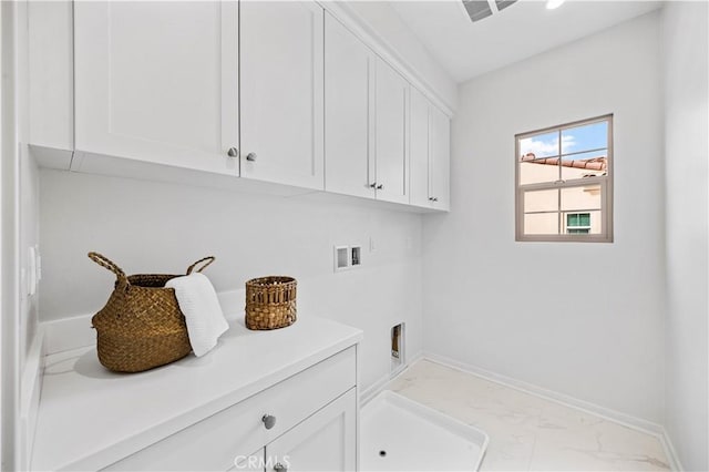 laundry area featuring marble finish floor, washer hookup, cabinet space, and baseboards