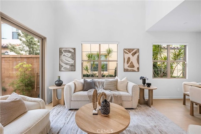 living area with a towering ceiling and baseboards