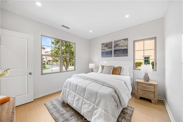 bedroom featuring light wood-style flooring, visible vents, baseboards, and recessed lighting