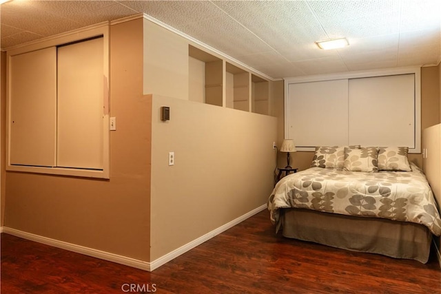 bedroom with a closet, baseboards, and wood finished floors