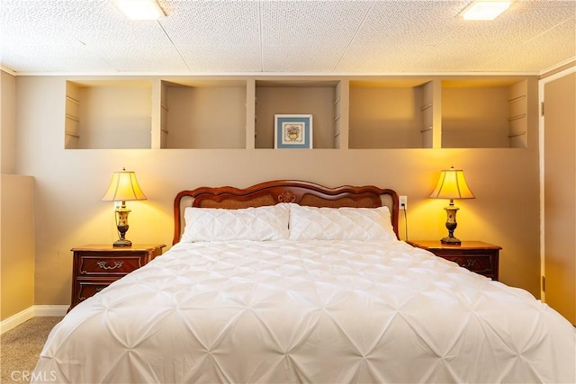 bedroom featuring a textured ceiling, carpet flooring, and baseboards