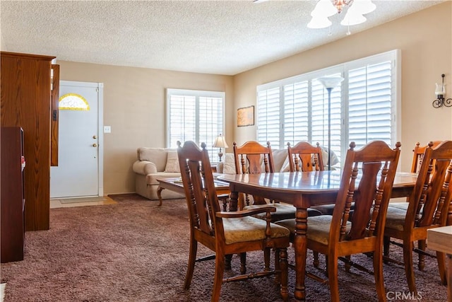 dining area with a textured ceiling and carpet flooring