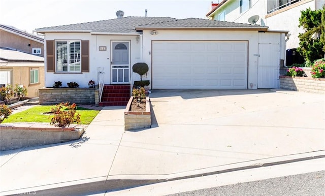 view of front facade with driveway, an attached garage, and stucco siding