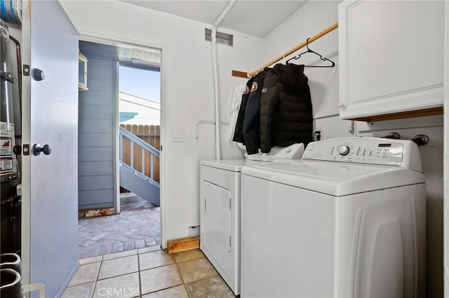 laundry room with visible vents, washing machine and dryer, and cabinet space