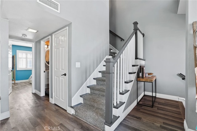 stairs featuring visible vents, baseboards, and wood finished floors