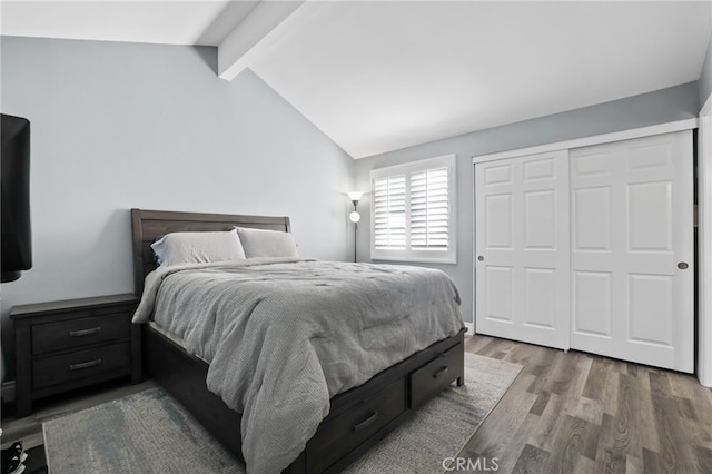 bedroom featuring a closet, lofted ceiling with beams, and wood finished floors