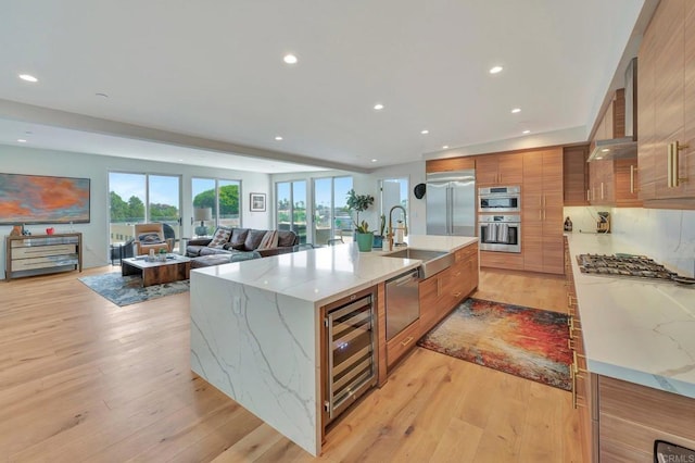 kitchen with brown cabinets, appliances with stainless steel finishes, a sink, modern cabinets, and beverage cooler