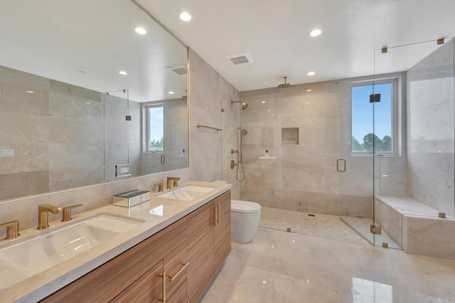 bathroom with a stall shower, visible vents, tile walls, and a sink