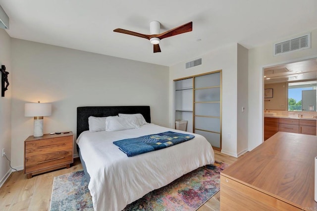 bedroom with light wood-style floors, a closet, visible vents, and a ceiling fan