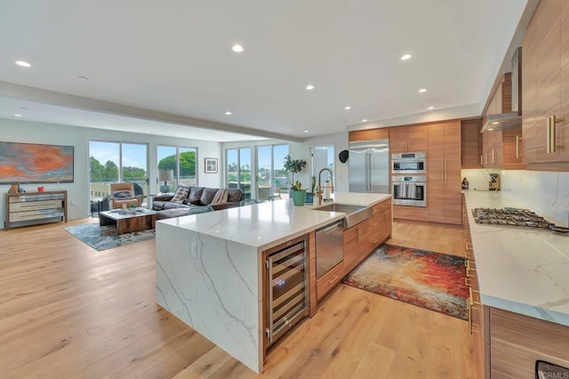 kitchen featuring a sink, beverage cooler, brown cabinetry, stainless steel appliances, and modern cabinets