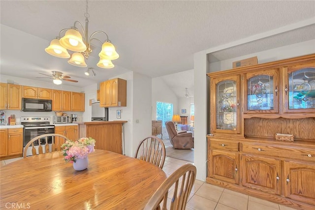 dining room featuring light tile patterned flooring, ceiling fan with notable chandelier, and a toaster