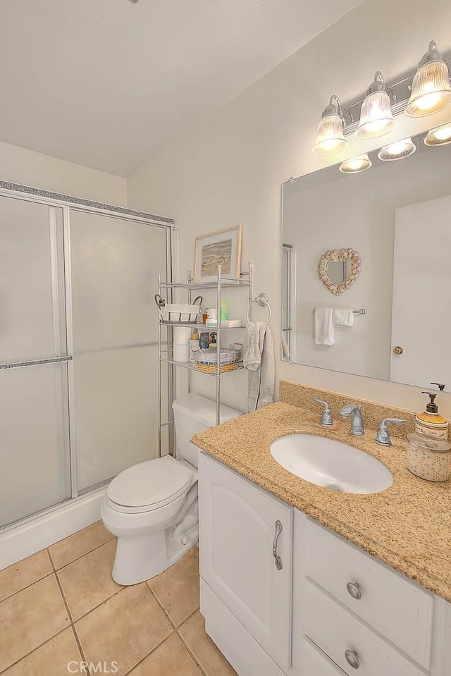bathroom with vanity, toilet, tile patterned floors, and a stall shower