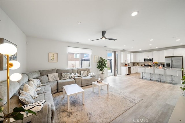 living area featuring light wood-style floors, recessed lighting, and a ceiling fan