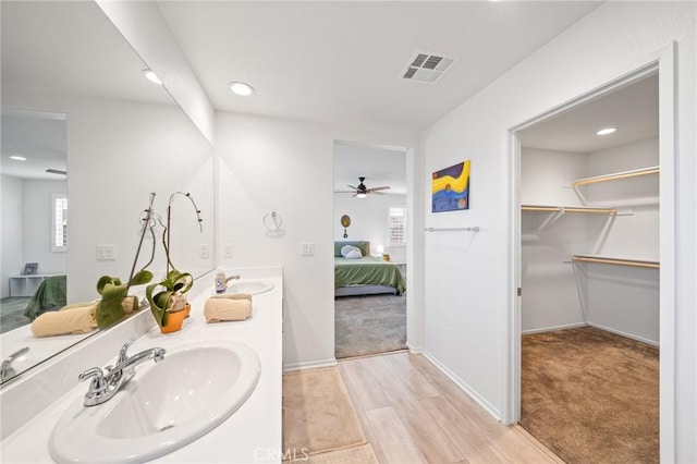 bathroom with ensuite bathroom, double vanity, a sink, and visible vents