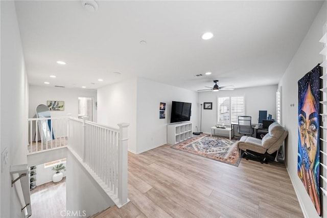 living area with recessed lighting, baseboards, and light wood finished floors