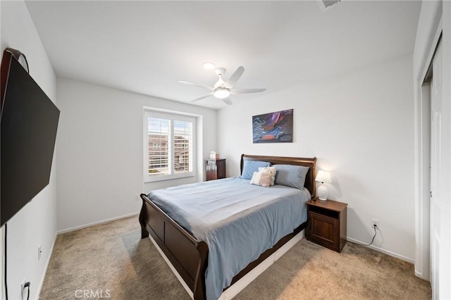 bedroom with ceiling fan, baseboards, and light colored carpet