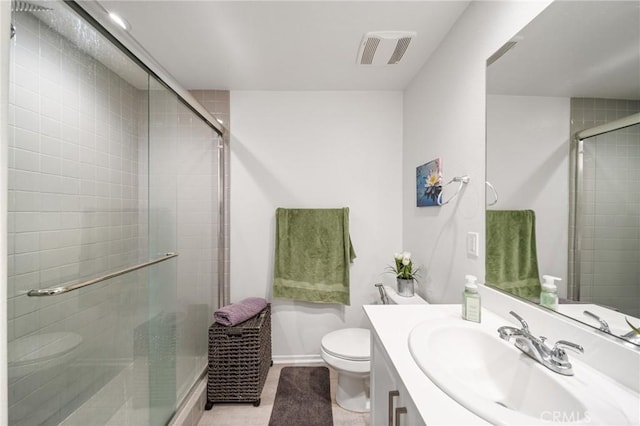 bathroom featuring toilet, vanity, visible vents, baseboards, and a shower stall