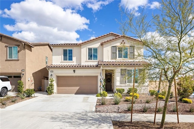 mediterranean / spanish house featuring a garage, driveway, and stucco siding