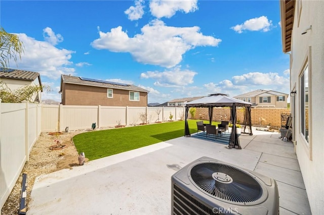 view of patio featuring a fenced backyard, a residential view, central AC unit, and a gazebo