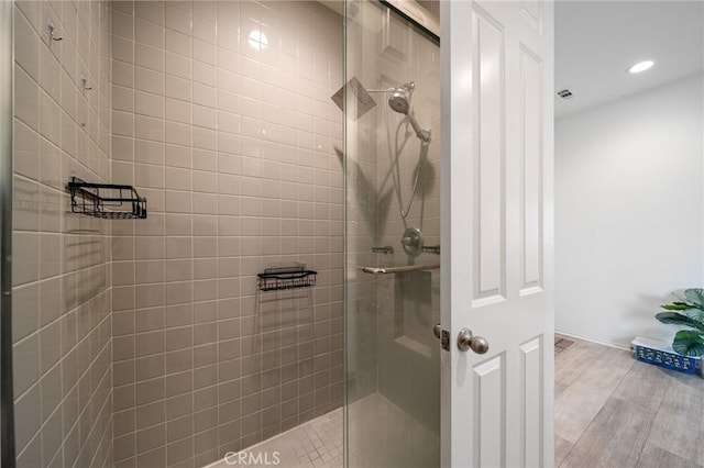 full bath with a stall shower, wood finished floors, visible vents, and recessed lighting