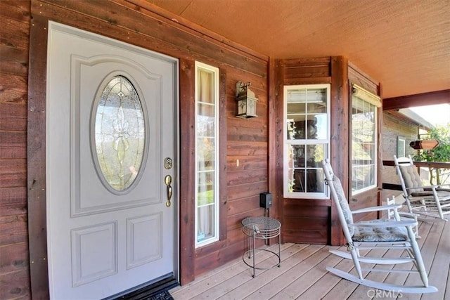 view of exterior entry featuring covered porch