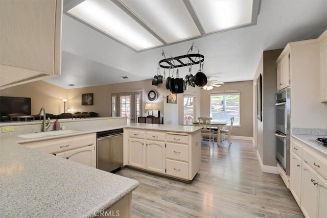 kitchen featuring a sink, light countertops, light wood-type flooring, and stainless steel appliances