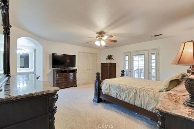 bedroom with visible vents, a ceiling fan, access to outside, arched walkways, and light colored carpet