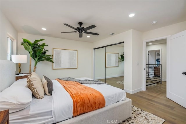 bedroom featuring recessed lighting, a closet, visible vents, wood finished floors, and baseboards