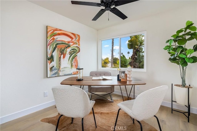 office area with a ceiling fan, baseboards, and wood finished floors