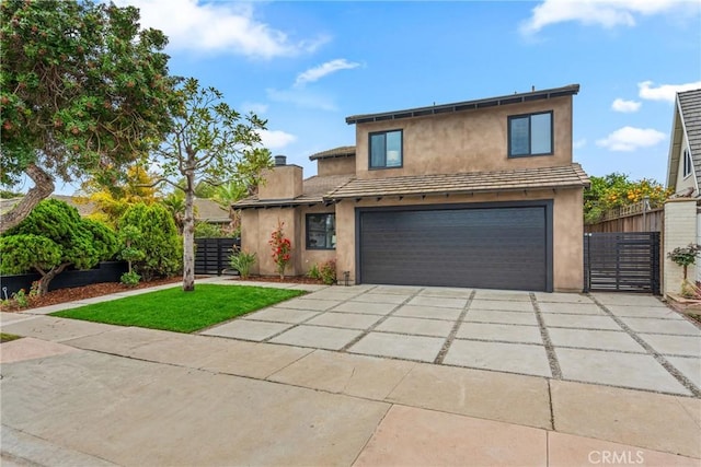 view of front of home with concrete driveway, an attached garage, fence, and stucco siding