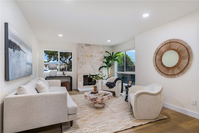 living room featuring recessed lighting, a fireplace, wood finished floors, and baseboards