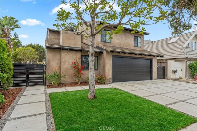 traditional-style home featuring a front yard, concrete driveway, fence, and an attached garage